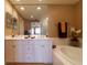 Bright bathroom featuring a double vanity, large mirror, soaking tub, and elegant decor at 265 Minorca Beach Way # 902, New Smyrna Beach, FL 32169