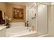 Bright bathroom showcasing a soaking tub with a glass shower and decorative wall art at 265 Minorca Beach Way # 902, New Smyrna Beach, FL 32169