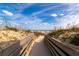 Sandy path lined with wooden planks leading to the beach with ocean views at 265 Minorca Beach Way # 902, New Smyrna Beach, FL 32169