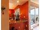 Cozy dining area featuring a marble countertop, vibrant orange walls, and an exterior view from a sliding glass door at 265 Minorca Beach Way # 902, New Smyrna Beach, FL 32169