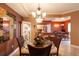 Elegant dining room with chandelier, glass table, wicker chairs and a view of the kitchen and additional dining space at 265 Minorca Beach Way # 902, New Smyrna Beach, FL 32169
