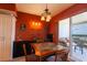 Dining area with an eye-catching light fixture, a wood table, and sliding doors to a balcony at 265 Minorca Beach Way # 902, New Smyrna Beach, FL 32169