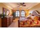 Cozy bedroom with a comfortable bed, arched windows with shutters, dresser, and a ceiling fan at 265 Minorca Beach Way # 902, New Smyrna Beach, FL 32169