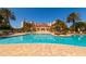 Inviting community pool surrounded by lounge chairs, palm trees, and resort style buildings at 265 Minorca Beach Way # 902, New Smyrna Beach, FL 32169