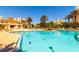 Inviting community pool surrounded by lounge chairs, palm trees, and resort style buildings at 265 Minorca Beach Way # 902, New Smyrna Beach, FL 32169