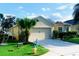 The exterior features a 2-car garage, a manicured lawn, and a beautiful palm tree at 2672 Star Coral Ln, New Smyrna Beach, FL 32168
