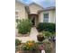 Inviting front entrance with a well-manicured garden, pathway, and a neutral-toned facade at 2672 Star Coral Ln, New Smyrna Beach, FL 32168