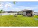 Wide shot of backyard shows patio with a large, grassy lawn at 2731 Neverland Dr, New Smyrna Beach, FL 32168