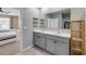 Bright bathroom featuring double sinks, grey vanity, shelves, and tile flooring at 2731 Neverland Dr, New Smyrna Beach, FL 32168
