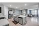 Open-concept kitchen with stainless steel appliances and an island overlooking the dining area and living room at 2731 Neverland Dr, New Smyrna Beach, FL 32168