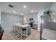 Stylish kitchen featuring gray cabinets, stainless steel appliances, an island with bar seating, and neutral tile flooring at 2731 Neverland Dr, New Smyrna Beach, FL 32168
