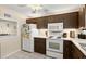 Cozy kitchen features white appliances, tile flooring and wood cabinets at 2901 N Halifax Ave # 215, Daytona Beach, FL 32118