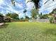 Expansive backyard with lush green grass, mature trees, and a privacy fence for outdoor enjoyment at 2918 Mango Tree Dr, Edgewater, FL 32141