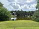 Scenic backyard view overlooking a serene pond with lush greenery and mature trees at 2918 Mango Tree Dr, Edgewater, FL 32141