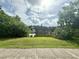 Serene backyard view featuring a calm pond surrounded by lush greenery and mature trees at 2918 Mango Tree Dr, Edgewater, FL 32141