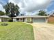 Inviting single-story home with a lush lawn, attached garage, and a cozy front porch at 2918 Mango Tree Dr, Edgewater, FL 32141
