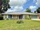 Charming single-story home with a well-manicured lawn, blue siding, and an attached garage at 2918 Mango Tree Dr, Edgewater, FL 32141