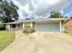Attractive home featuring a large garage, well-kept lawn, and inviting front entrance at 2918 Mango Tree Dr, Edgewater, FL 32141