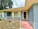 Inviting front porch with brick entrance leading to a quaint, blue home with white trim accents at 2918 Mango Tree Dr, Edgewater, FL 32141