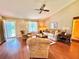 Bright and airy living room with a ceiling fan, natural lighting, and cozy seating at 2918 Mango Tree Dr, Edgewater, FL 32141