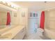 Bright bathroom featuring a light vanity, tile floors, and a shower with a red curtain at 3023 S Atlantic Ave # 8010, Daytona Beach, FL 32118