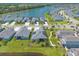 Aerial view showcases homes,solar panels, a community lake, and serene surroundings at 3027 Portofino Blvd, New Smyrna Beach, FL 32168
