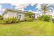 Well-manicured backyard with lush lawn and beautiful landscaping around the fence at 3027 Portofino Blvd, New Smyrna Beach, FL 32168