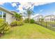 Expansive backyard with tropical landscaping that is fenced and has a pond behind the fence at 3027 Portofino Blvd, New Smyrna Beach, FL 32168