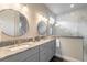 Elegant bathroom featuring double sinks with granite countertops, sleek fixtures, and a glass-enclosed shower at 3027 Portofino Blvd, New Smyrna Beach, FL 32168