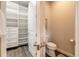 Bathroom with open door to organized closet and a view of the toilet and closed door at 3027 Portofino Blvd, New Smyrna Beach, FL 32168