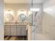 Elegant bathroom with dual vanities, framed round mirrors, and a glass-enclosed marble shower at 3027 Portofino Blvd, New Smyrna Beach, FL 32168