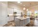 Eat-in kitchen featuring a stainless steel refrigerator, a center island, and wood plank floors at 3027 Portofino Blvd, New Smyrna Beach, FL 32168