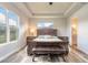 A cozy bedroom featuring a tray ceiling, and a large window with views of a lush, outdoor landscape at 3027 Portofino Blvd, New Smyrna Beach, FL 32168
