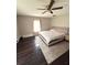 Comfortable main bedroom features a ceiling fan, a large bed, a bedside table, and wood flooring at 306 Murray St, New Smyrna Beach, FL 32168