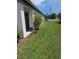 A lush backyard with well-manicured lawn, mulch beds, and a vibrant flowering tree at 3103 Nova Scotia Way, New Smyrna Beach, FL 32168