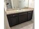 Bathroom vanity with dark cabinets, neutral countertops and a mirrored wall cabinet at 3103 Nova Scotia Way, New Smyrna Beach, FL 32168