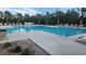 Inviting community pool with plenty of lounge chairs, surrounded by lush landscaping and tall palms at 3103 Nova Scotia Way, New Smyrna Beach, FL 32168