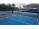 Vibrant blue and grey community pickleball courts provide a fun recreational activity for residents at 3103 Nova Scotia Way, New Smyrna Beach, FL 32168