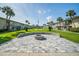 Community fire pit, lush landscaping, and inviting lawn with palm trees, create perfect place for relaxation at 335 N Causeway # E3, New Smyrna Beach, FL 32169