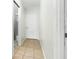 Hallway view with a neutral color palette, tile flooring, and access to a bathroom at 335 N Causeway # E3, New Smyrna Beach, FL 32169