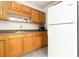 Bright kitchen with stainless steel sink, and plentiful wood cabinets and a white refrigerator at 335 N Causeway # E3, New Smyrna Beach, FL 32169