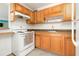 Bright kitchen with stainless steel sink, modern white range, and ample wood cabinets at 335 N Causeway # E3, New Smyrna Beach, FL 32169