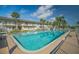 Community pool with blue water, surrounding palm trees, and a multi-story building backdrop at 335 N Causeway # E3, New Smyrna Beach, FL 32169