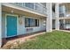 Exterior of condo with grassy area and a teal front door with one window that is open at 3509 S Atlantic Ave # 109, New Smyrna Beach, FL 32169