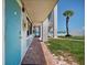 Exterior of a teal door condo with a palm tree and beach view at 3509 S Atlantic Ave # 109, New Smyrna Beach, FL 32169