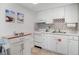 Charming kitchen with white cabinets, white appliances, wood counter, and patterned backsplash at 3509 S Atlantic Ave # 109, New Smyrna Beach, FL 32169
