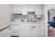 Well-equipped kitchen features white cabinets, modern appliances, and patterned backsplash at 3509 S Atlantic Ave # 109, New Smyrna Beach, FL 32169