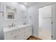 Bright bathroom features double sinks with white cabinets, white countertops and a light wood floor at 357 Hearthstone Ter, Port Orange, FL 32127