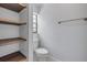 Powder room with white toilet, window, dark wood shelves and beige tiled flooring at 357 Hearthstone Ter, Port Orange, FL 32127