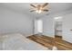 Bedroom with a decorative bed, ceiling fan, wood-look floors, closet and bathroom access at 357 Hearthstone Ter, Port Orange, FL 32127
